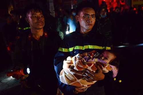 Lực lượng làm nhiệm vụ đưa các cháu nhỏ ra khỏi khu vực có nhiều đám khói. Ảnh- Anh Tuấn.