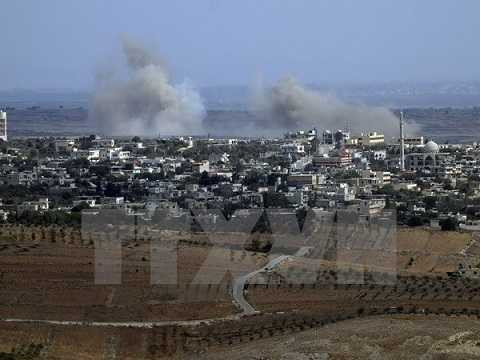 Khói bốc lên từ làng Jubata al-Khashab của Syria sau một vụ không kích của trực thăng quân sự ngày 13/10