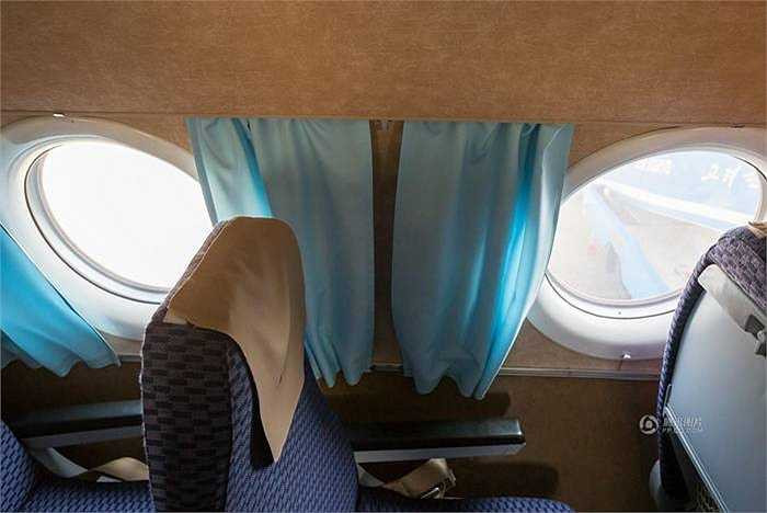 Một máy bay không có tấm chắn cửa sổ mà được thay thế bằng một rèm cửa bằng vải màu xanh