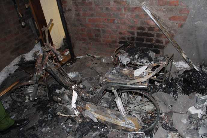 Một chiếc xe máy dựng gần đó cũng bị ngọn lửa thiêu trụi, trơ lại bộ khung - Ảnh: Phạm Đức