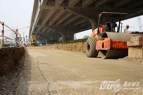 Sau khi bóc dỡ cỏ và cây cảnh phía trên, đơn vị thi công đào sâu khoảng một mét so với mặt đường, sau đó đổ cát, đá dăm, san ủi và cho xe lu nén chặt lòng đường để trải nhựa.
