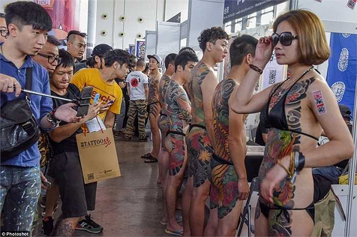 Nhiều du khách hiếu kỳ chụp ảnh hình xăm trên cơ thể thí sinh