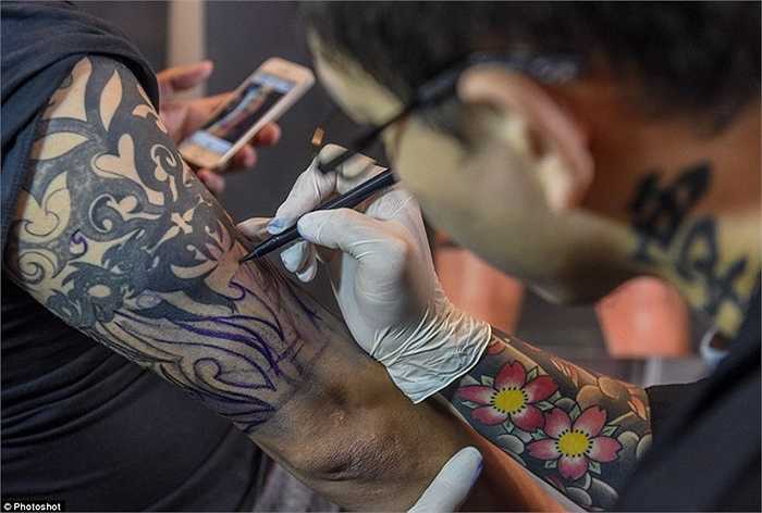 Nghệ nhân vẽ bằng bút mực trước khi dùng kim xăm