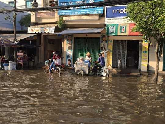 Nước ngập đầy đường, tràn cả vào nhà dân, gây khó khăn cho việc mua bán, sinh hoạt.