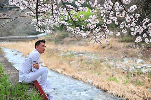 Nam ca sĩ trầm mình giữa vẻ đẹp thiên nhiên tuyệt vời của rừng hoa anh đào tại xứ sở Mặt trời mọc.