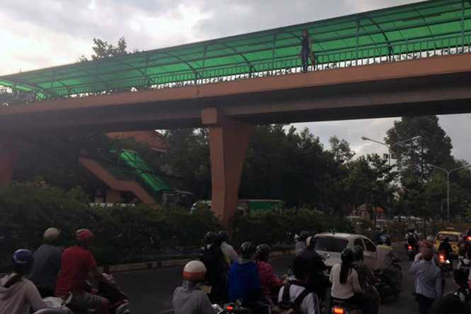 Cô gái đứng trên cầu vượt bộ hành trước khi nhày xuống đường - Ảnh: A.L