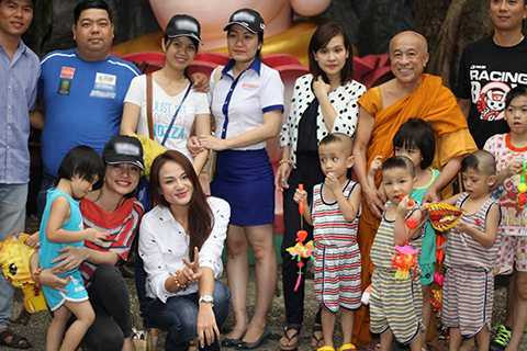 Nữ ca sĩ hạnh phúc lưu giữ kỉ niệm cùng các em nhỏ và sư thầy trụ trì của chùa Kỳ Quang.
