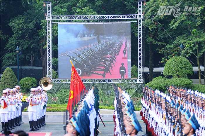 21 phát đại bác chào đón ông Tập Cận Bình được tường thuật qua màn hình lớn - Ảnh: Tùng Đinh