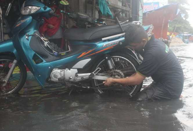 Một thợ sửa xe chết máy trên đường An Dương Vương - Ảnh: Đức Phú