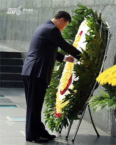 Ông Tập Cận Bình chỉnh lại ruy băng trên vòng hoa viếng Bác. (Ảnh: Phạm Thành)