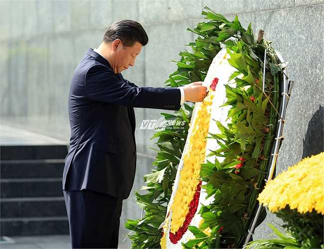 Ông Tập Cận Bình chỉnh lại ruy băng trên vòng hoa viếng Bác. (Ảnh: Phạm Thành)