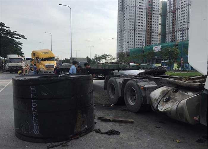 Lực thắng gấp khiến cuộn thép hàng chục tấn dồn về trước đập mạnh vào cabin và đứt xích rơi trúng thùng dầu rồi văng xuống đường...