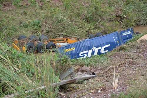 Đầu kéo, rơ-moóc và thùng hàng một xe container bị đứt rời, văng xuống dưới vực. Đầu kéo, rơ-moóc và thùng hàng một xe container bị đứt rời, văng xuống dưới vực.