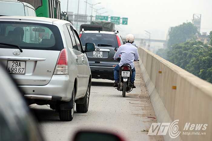 Phía đường cao tốc trên cao, rất nhiều ô tô đang lưu thông trên tuyến đường này cũng phải chịu chung cảnh tắc đường, chỉ còn một số ít người điều khiển xe máy liều mạng chạy lên đường cao tốc để vượt qua ngã tư đang bị ùn tắc.