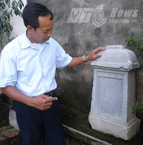 Ông Phúc bên tấm bia cổ tương truyền có từ thời cụ Tổng Cóc