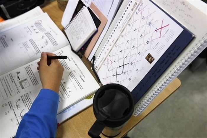 Một bàn học với cuốn lịch đánh dấu ngày thi