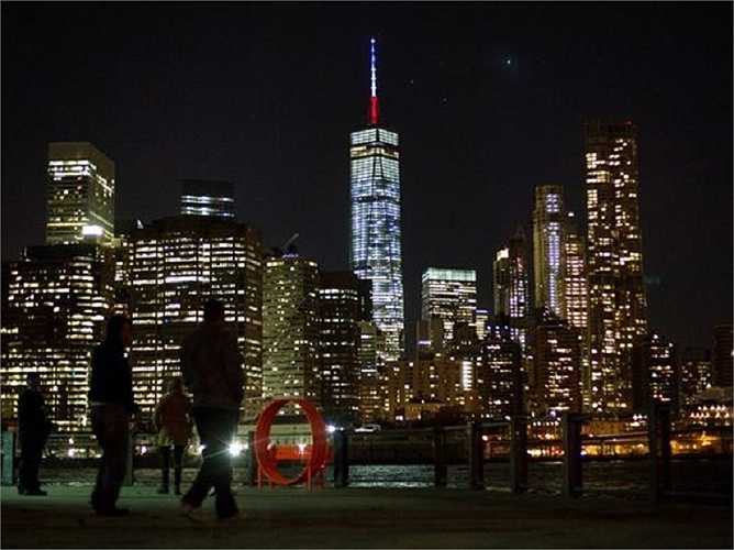 Cột tháp trên trung tâm Thương mại Thế giới chuyển sang màu cờ Pháp, xanh, trắng và đỏ, để thể hiện niềm tiếc thương các nạn nhân vụ tấn công khủng bố kinh hoàng ở Paris hôm 13/11