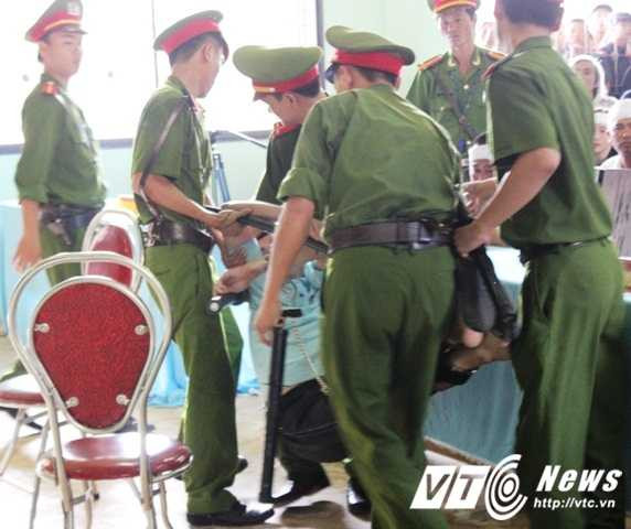 Lực lượng chức năng phải khiêng bị cáo Hồ Chí Bảo vào phiên tòa.