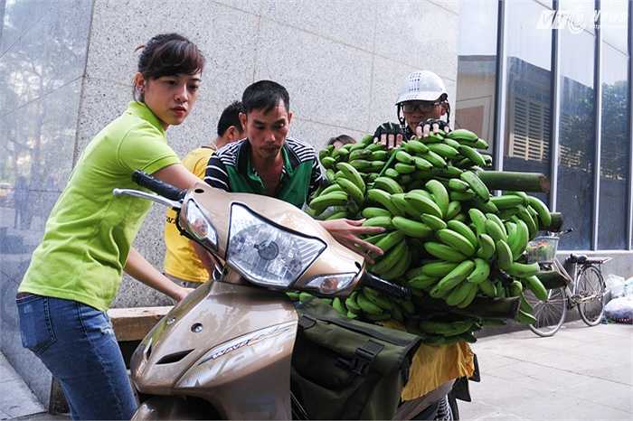 Nhân viên kênh VTC16 giúp người vận chuyển buộc chuối lên xe trước khi giao cho khách hàng