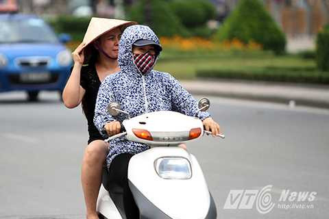 Nhiều phụ nữ ra đường phải mặc áo chống nắng và ô dù đã giữa tháng 11 dương lịch.