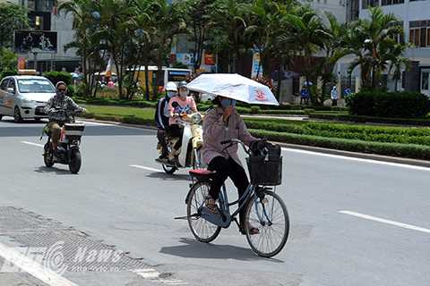 Hay vừa đi xe đạp vừa che ô bất chấp nguy hiểm.