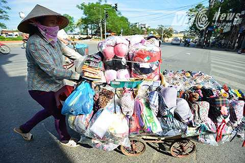 Người phụ nữ bán hàng rong này than thở: ‘Đi bộ cả ngày dưới cái nắng thế này rất mất sức, thế mà tôi vẫn phải mang thêm một chiếc áo gió đề phòng tối về muộn trời lại chuyển lạnh.’