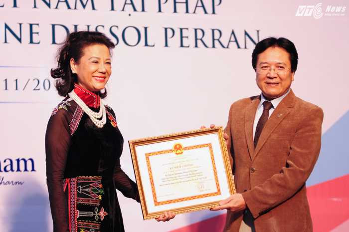 Ông Vương Duy Biên tặng kỷ niệm chương Vì sự nghiệp văn hóa, thể thao và du lịch cho bà Anoa - Ảnh: Tùng Đinh