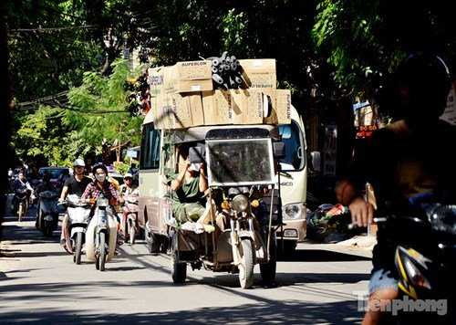 Một chiếc xe ba bánh tự chế chở hàng hoá cao ngang chiếc xe <a href='https://vtcnews.vn/oto-xe-may.31.0.html' >ô tô</a> khách 29 chỗ đi phía sau. Hình ảnh được ghi lại trên đường Hoàng Hoa Thám (Ba Đình, Hà Nội).