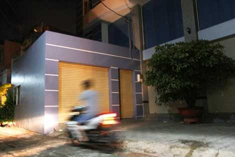 Thi thể người đàn ông được phát hiện trước cửa gara cạnh chậu mai. Ảnh: HOÀNG GIANG