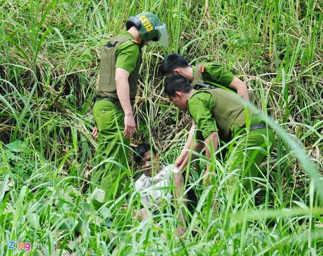 Bị công an bao vây, lại đuối sức nên sau 30 phút, người này lộ diện. Cảnh sát đưa cây gỗ cho thanh niên nắm rồi kéo ​lên bờ.