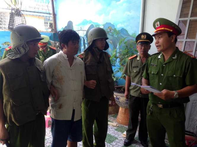 Đối tượng Bùi Đức Sơn đang nghe cơ quan điều tra đọc lệnh khám xét, bắt tạm giam - Ảnh: Đ.Hà