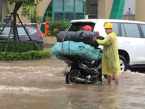 Công nhân thoát nước có mặt, mở các nắp cống để nước tiêu thoát nhanh hơn.