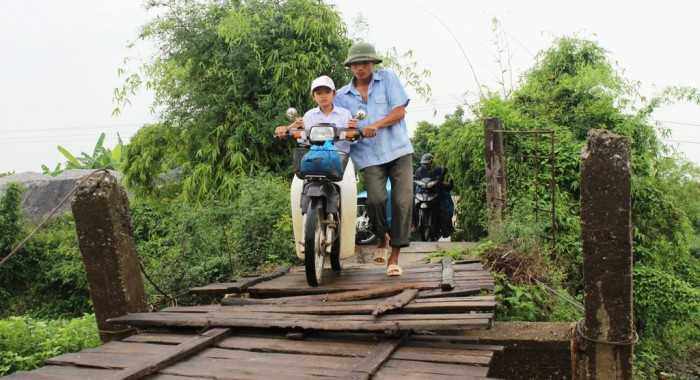 Dân 'nín thở' đi qua cây cầu 'dính chặt' lòng sông