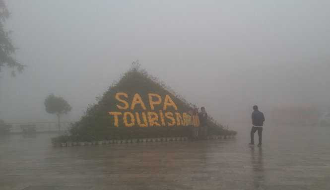 Du khách chụp ảnh trong sương mù và rét lạnh - Ảnh: Hồng Thảo