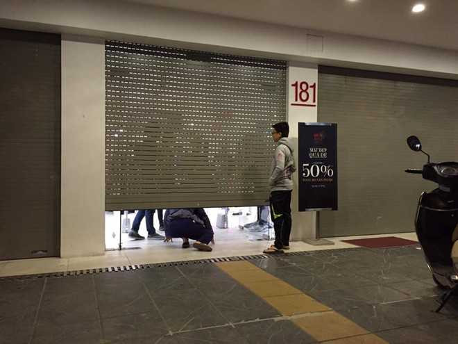 Trong ảnh là một khách hàng cố chui qua cửa sếp đã khép để vào mua hàng giảm giá tại một cửa hiệu trên đường Giảng Võ (Hà Nội). Ảnh: Khánh Linh.