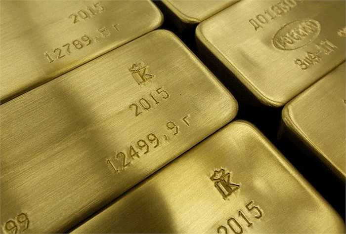 Công nhân xếp những thỏi vàng đã khắc thông tin vào thùng hàng trên xe đẩy. 