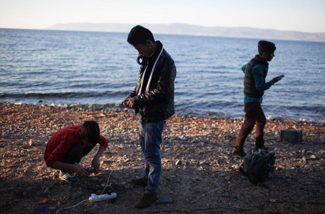 Người tị nạn sạc điện thoại tại Lesbos. Ảnh: Cnet.