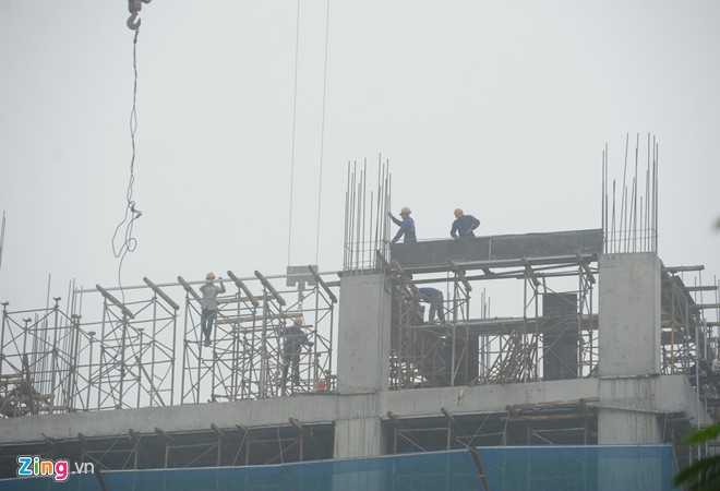 Công nhân công trường xây dựng làm việc trong điều kiện thời tiết không thuận lợi.