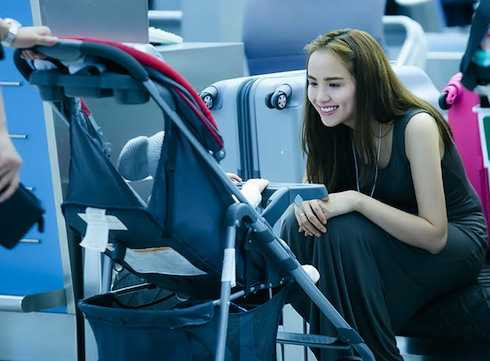 Diễm Hương trông bé Noah trong lúc chồng làm thủ tục tại sân bay.