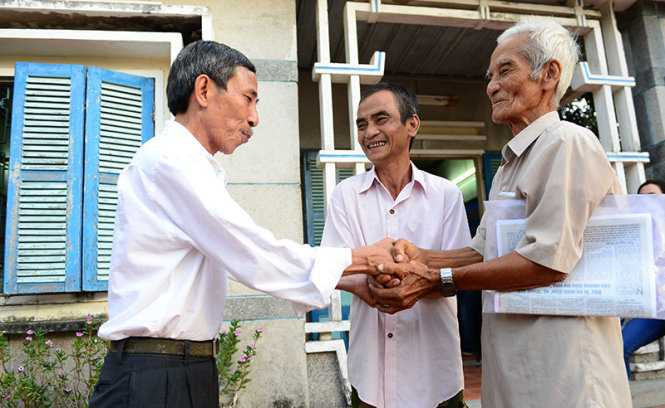 Cha con ông Huỳnh Văn Truyện và Huỳnh Văn Nén bắt tay ân nhân của mình là thầy giáo Nguyễn Thận (bìa trái) - Ảnh: Quang Định