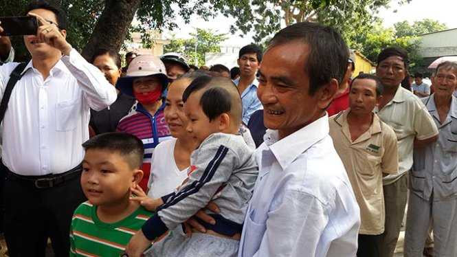 Ông Huỳnh Văn Nén đùa vui với cháu trước khi vào khu vực xin lỗi - Ảnh: NGUYỄN NAM