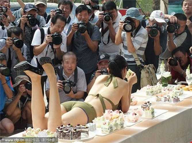 Chiêu dùng gái đẹp để câu khách mua nhà: Các nhà kinh doanh bất động sản tại Trung Quốc đã tìm đủ mọi cách để thu hút khách hàng từ việc thuê người đẹp trình diễn tới việc vẽ lên người họ. Ảnh: Người mẫu nằm trên bàn tiệc tại hội chợ nhà đất ở Yichang, tỉnh Hồ Bắc, Trung Quốc. 