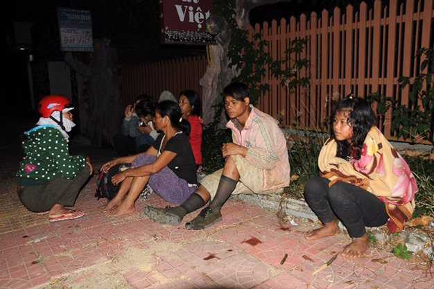 Những hành khách may mắn không bị thương hoặc bị xây xát nhẹ ngồi ủ rũ bên vệ đường sau tai nạn