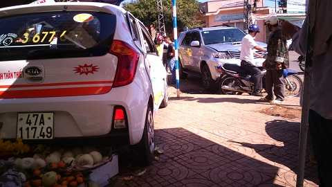 Đuôi chiếc taxi lọt thỏm vào sạp hoa quả (Ảnh: Tây Sơn)