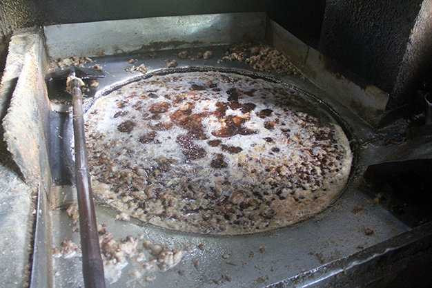 Mỡ được chiên trên chảo khổng lồ và dùng xẻng để vớt - Ảnh: Đoàn Cường