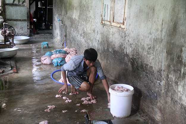 Nhân viên của cơ sở hốt mỡ trên nền xi măng bẩn thỉu - Ảnh: Đoàn Cường