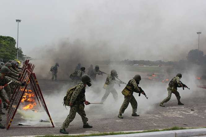 Các chiến sĩ bộ đội hóa học tiến về phía trước trong làn khói độc làm nhiệm vụ