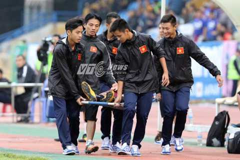 Trọng Đại rời sân bằng cáng (Ảnh: Quang Minh)