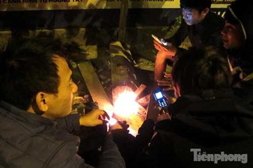 Nhóm bạn trẻ tụ tập bên đống lửa trên đường Nguyễn Xiển (Hà Nội) sưởi ấm.