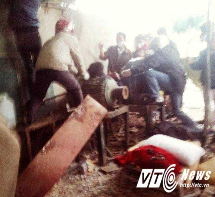 Lực lượng chức năng cùng người dân đưa thi thể nạn nhân khỏi hiện trường.